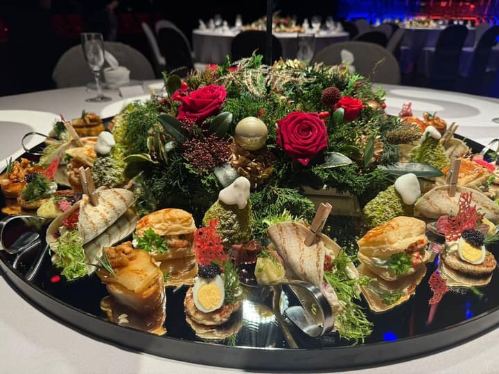 Festliches Fingerfood auf einem Spiegeltablett mit Blumen