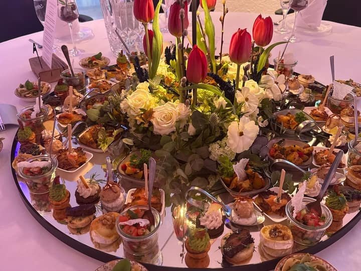Großer Fingerfood-Tisch mit Blumenarrangement