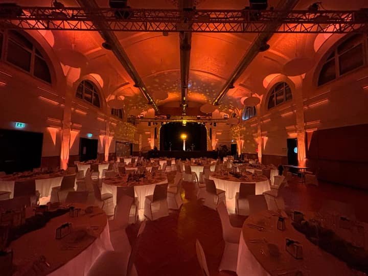 Saal mit Bühne und festlicher Beleuchtung